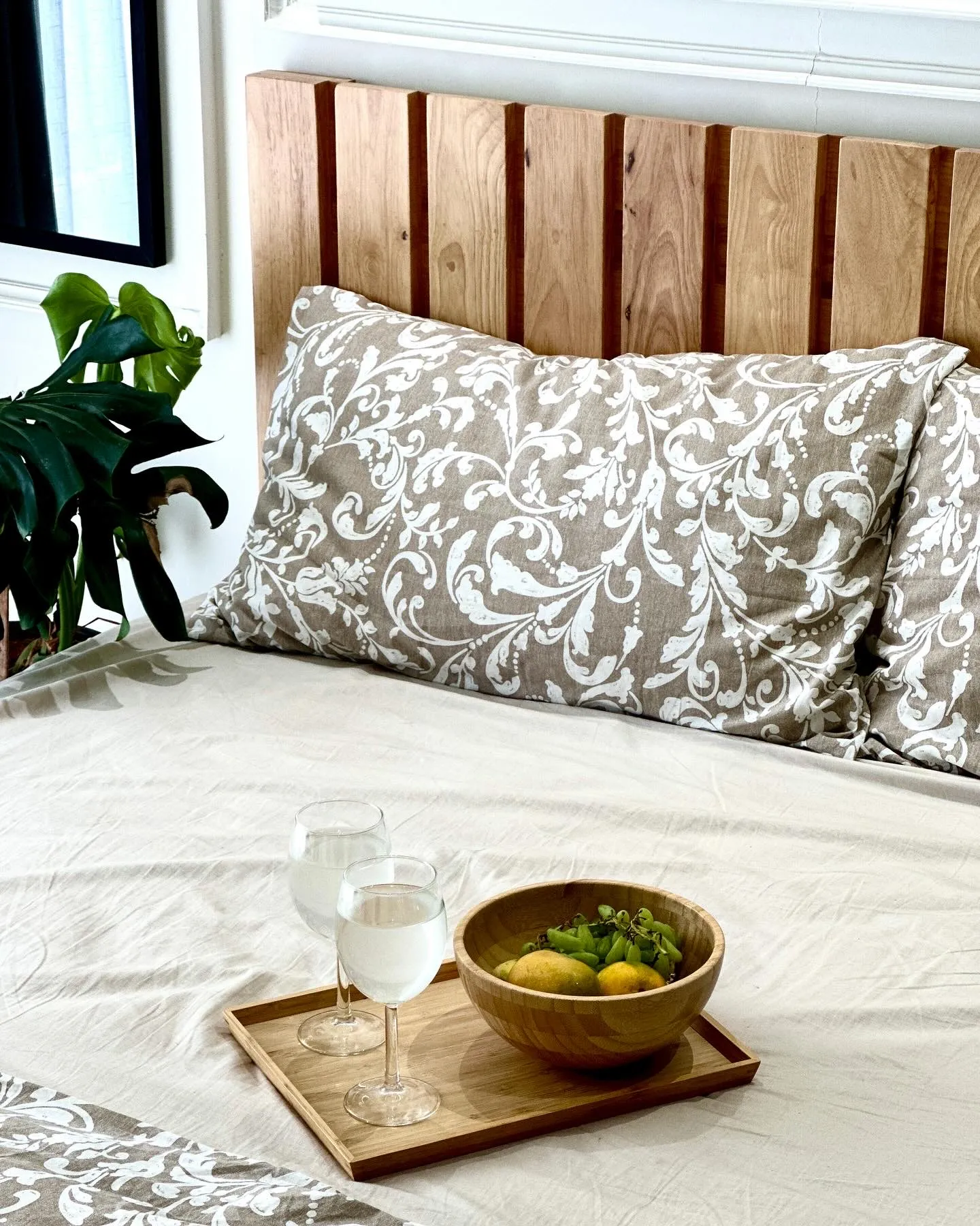 Bed with oak-slat headboard and patterned linen — The Aakar